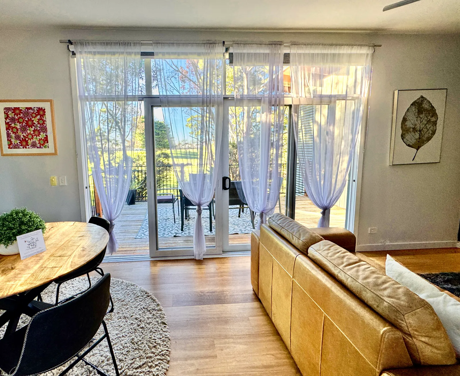 Open-plan dining and living area with sliding doors to the furnished deck — Two-bedroom Villa 107, Cowes, Phillip Island