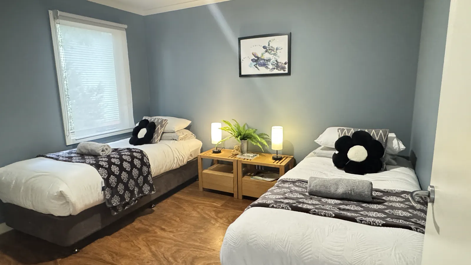 Twin bedroom with two single beds, patterned throws and a shared bedside table — Two-bedroom Villa 107, Cowes, Phillip Island