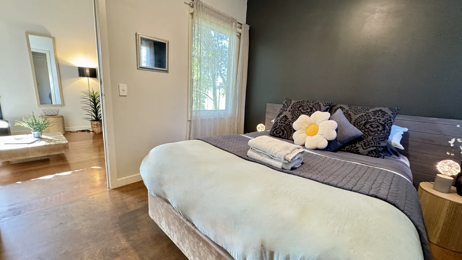 Bedroom with a white quilt, flower cushion and doorway to the ensuite — Three-bedroom Villa 115, Cowes, Phillip Island
