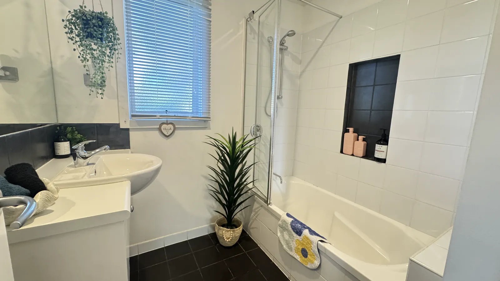 Bathroom with a shower over the bathtub, vanity and window — Three-bedroom Villa 115, Cowes, Phillip Island