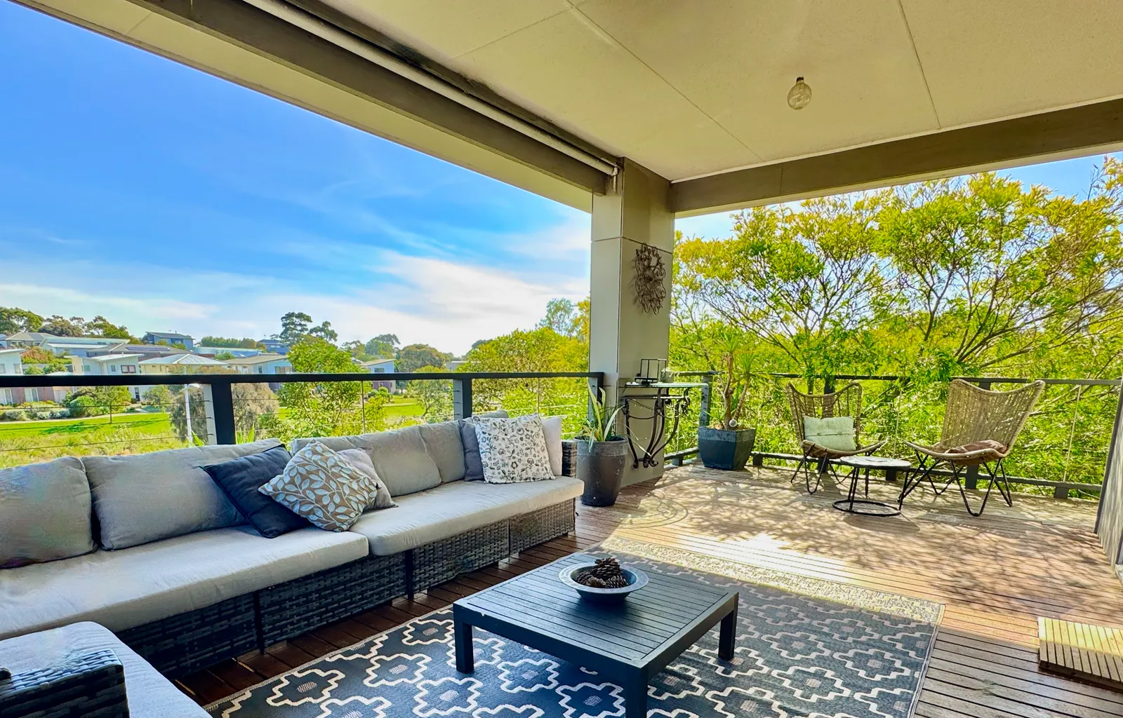 Covered deck with outdoor sofa and dining table overlooking the park — Coastal Tones holiday home, Cowes, Phillip Island