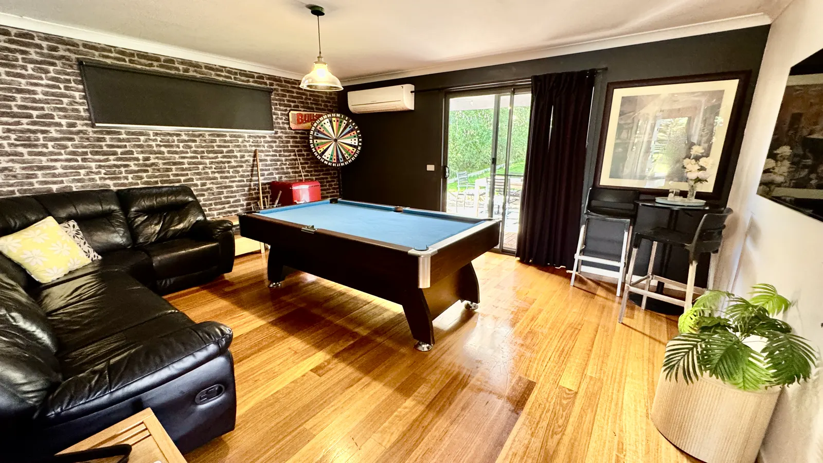 Games room with a pool table, black leather sofas and timber floors — Coastal Tones holiday home, Cowes, Phillip Island