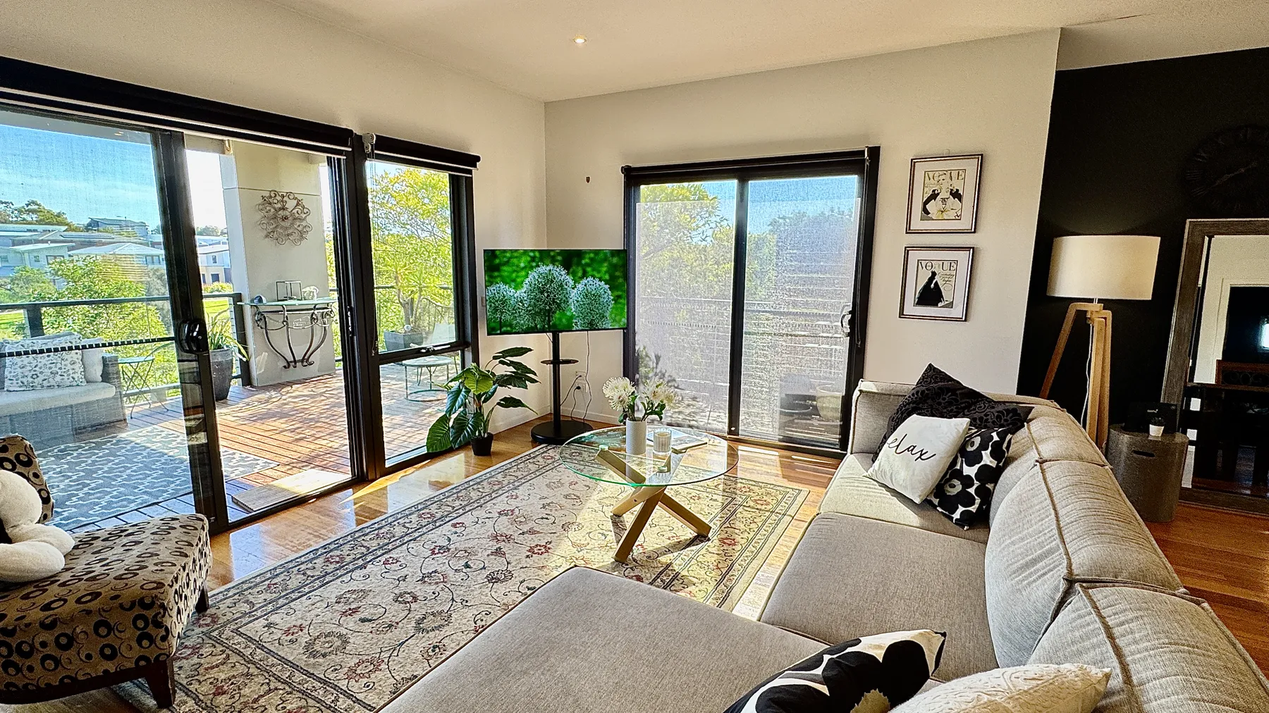 Bright living room with a white sofa and a view across the park — Coastal Tones holiday home, Cowes, Phillip Island