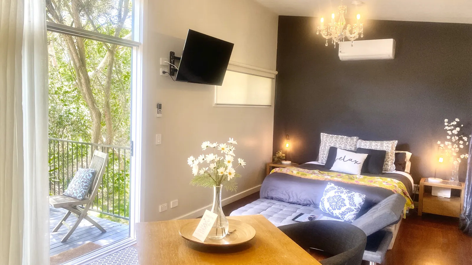 Romantic studio bedroom with warm bedside lamps and sliding doors to the deck — Studio Spa Villa 127, Cowes, Phillip Island