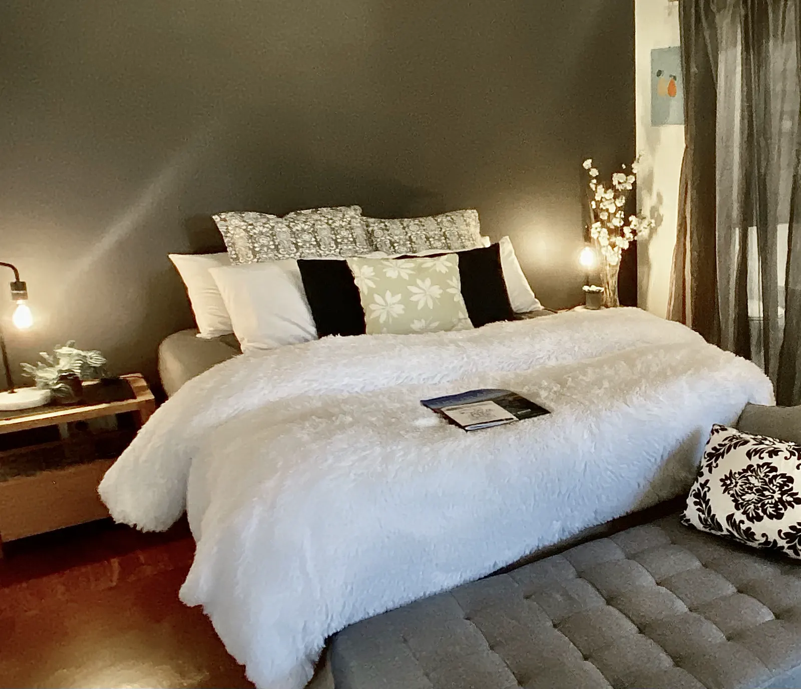 Studio bed with a white quilt, bedside lamps and a cushioned bench — Studio Spa Villa 127, Cowes, Phillip Island