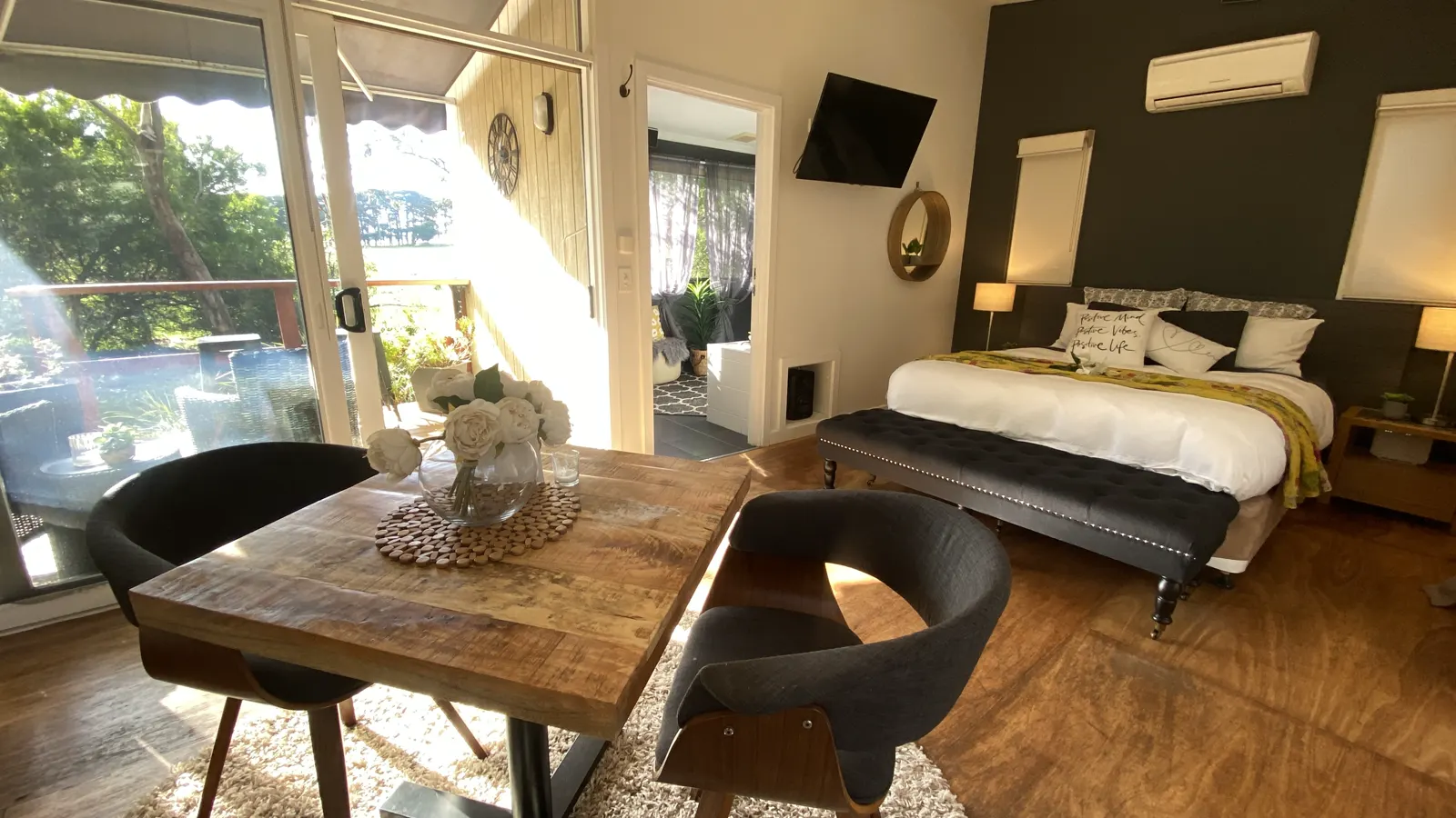 Couples' studio bedroom with a timber dining table and garden-facing windows — Couples Private Spa Retreat Villa 117, Cowes, Phillip Island