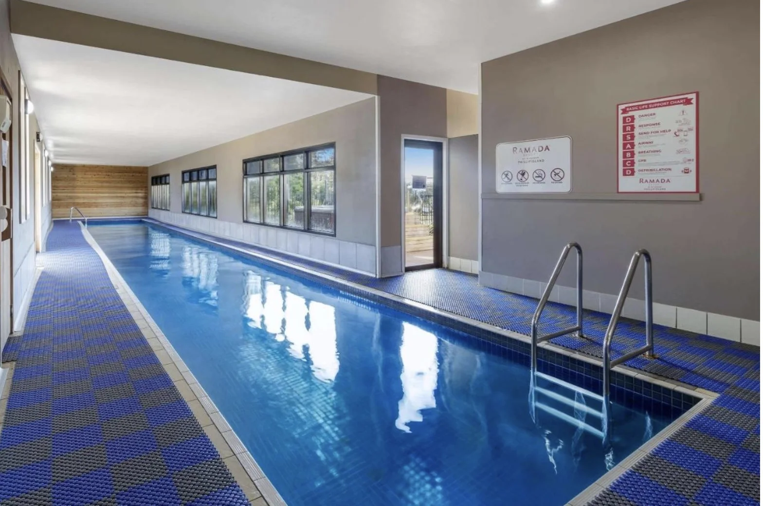Indoor resort swimming pool with large windows overlooking the grounds