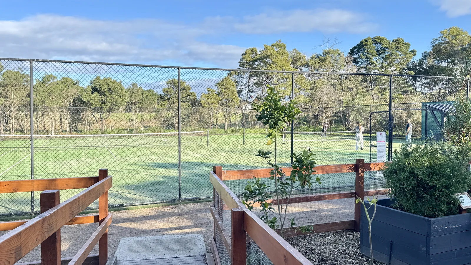 A tennis game on the resort court surrounded by bushland